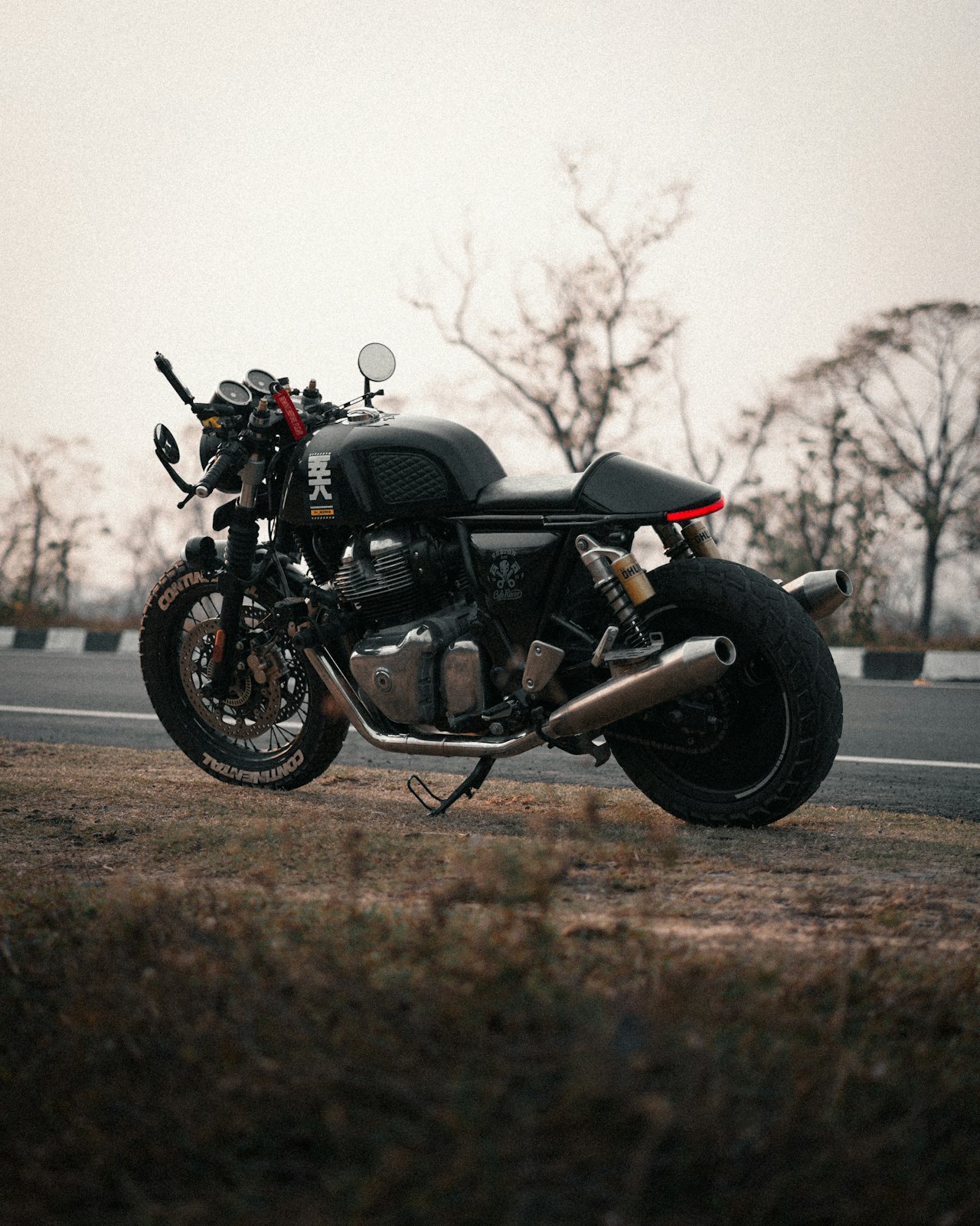 A clean motorcycle under a breathable cover on paddock stands in a tidy garage for winter